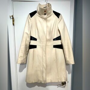 Chic & flattering wool coat. Cream with vegan leather accents & gold hardware.